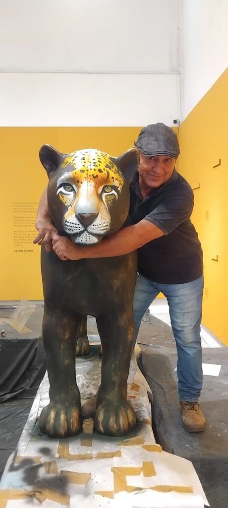 Ton Neves posa ao lado da escultura de uma onça-pintada, obra produzida para o evento Jaguar Parade, em exposição no Centro Cultural Tatajuba, em Imperatriz.